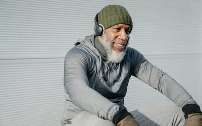 A happy retired gentleman listening to music on his headphones