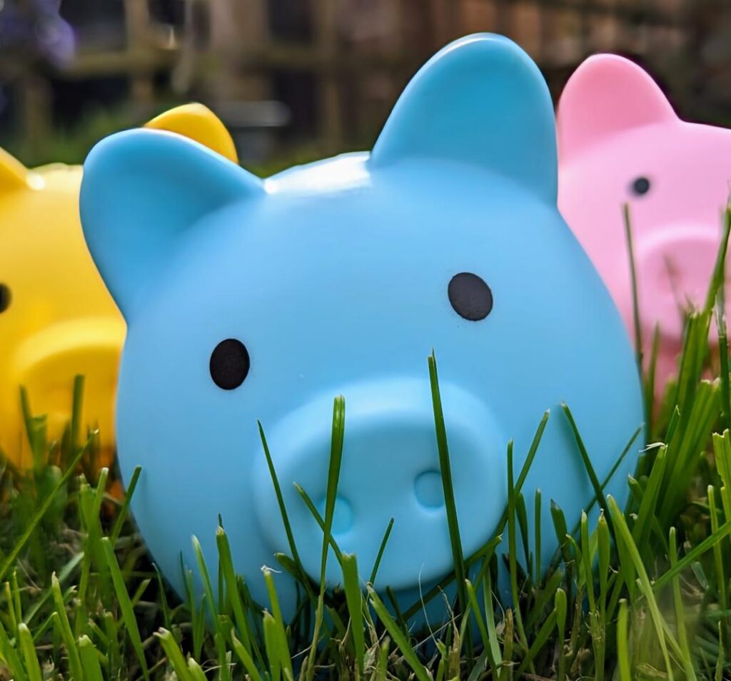 Blue piggy bank with a pink and yellow one in the background