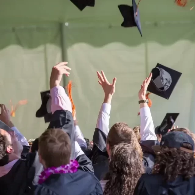 Students throwing their mortar boards in the air