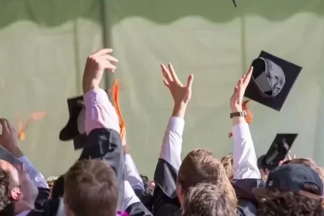Students throwing their mortar boards in the air